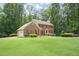 A classic brick home with a two-car garage and a spacious front yard, nestled amongst mature trees at 2101 Breconridge Sw Dr, Marietta, GA 30064