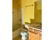 Bright yellow bathroom features a shower-tub combination and a wooden vanity at 2653 Parkway Trl, Lithonia, GA 30058