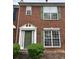 Charming brick townhouse with green door and shutters and mature bushes at 2653 Parkway Trl, Lithonia, GA 30058