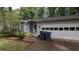 Quaint single Gathering home featuring a two-car garage and light blue vinyl siding at 345 Deerwood Dr, Suwanee, GA 30024