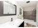 Bathroom with a modern vanity, dark framed mirror, and tiled shower/tub at 6864 Maddox Rd, Morrow, GA 30260