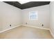 Bedroom with painted black ceiling, window, and neutral colored walls at 6864 Maddox Rd, Morrow, GA 30260