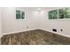 Cozy bedroom featuring hardwood floors, fresh paint, and large double windows at 6864 Maddox Rd, Morrow, GA 30260