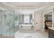Bright bathroom featuring a soaking tub under a large window and a glass-enclosed shower at 1225 Elk Ridge Cv, Alpharetta, GA 30005