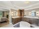 Bathroom showcasing double vanities, a built-in linen closet, and an elegant white leather ottoman at 1225 Elk Ridge Cv, Alpharetta, GA 30005