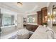 Bright bathroom featuring a bathtub, double vanity, chandelier, and white countertops at 1225 Elk Ridge Cv, Alpharetta, GA 30005