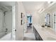 Well-lit bathroom featuring a vanity, large mirror, and tub/shower combo with a view of an adjacent bedroom at 1225 Elk Ridge Cv, Alpharetta, GA 30005