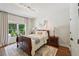 Well-lit bedroom features a sleigh bed, hardwood floors, neutral walls, and natural light from a large window at 1225 Elk Ridge Cv, Alpharetta, GA 30005