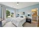 Inviting bedroom with a large window offering scenic views and a doorway to a full bathroom at 1225 Elk Ridge Cv, Alpharetta, GA 30005