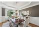 Dining room with hardwood floors, elegant trim, modern lighting, and views of the landscaped yard at 1225 Elk Ridge Cv, Alpharetta, GA 30005