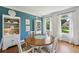 Bright dining room with hardwood floors, white wainscoting, and a round table near large windows at 1225 Elk Ridge Cv, Alpharetta, GA 30005