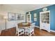 Dining room with wood floors, blue accent wall, and picture frame molding at 1225 Elk Ridge Cv, Alpharetta, GA 30005