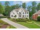 Elegant two-story home featuring a well-manicured lawn and a long, curved driveway at 1225 Elk Ridge Cv, Alpharetta, GA 30005