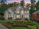 Elegant two-story home featuring lush landscaping, symmetrical design, and a welcoming entrance at 1225 Elk Ridge Cv, Alpharetta, GA 30005