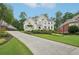 Charming two-story home featuring a manicured front yard and a long driveway leading to the residence at 1225 Elk Ridge Cv, Alpharetta, GA 30005