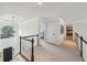Upstairs hallway featuring dark railings, neutral carpet, modern lighting, and views of the foyer below at 1225 Elk Ridge Cv, Alpharetta, GA 30005