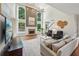 Bright living room with a fireplace, soaring ceilings, large windows overlooking pool, and stylish decor at 1225 Elk Ridge Cv, Alpharetta, GA 30005