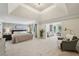 Luxurious main bedroom featuring tray ceilings, neutral tones, sitting area and lots of space at 1225 Elk Ridge Cv, Alpharetta, GA 30005