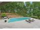 Inviting backyard pool surrounded by lush greenery and lounge chairs at 1225 Elk Ridge Cv, Alpharetta, GA 30005