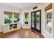 Bright sunroom with large windows, wooden floors, and doors leading to outdoor patio at 1225 Elk Ridge Cv, Alpharetta, GA 30005