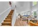 Bright living room with hardwood floors, a staircase, and a view into the kitchen at 190 Crestworth Ct, Powder Springs, GA 30127