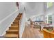 Open-concept living room with hardwood floors, a staircase, and a comfortable seating area at 190 Crestworth Ct, Powder Springs, GA 30127