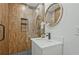 Sleek bathroom with floating vanity, round mirror, and glass-enclosed shower featuring brown tiling at 2648 Varner Ne Dr, Atlanta, GA 30345