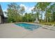 Inviting backyard pool with a cozy outdoor fireplace, surrounded by lush landscaping and modern lounge chairs at 2648 Varner Ne Dr, Atlanta, GA 30345
