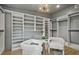 Spacious walk-in closet with custom shelving, stylish chairs, and a modern light fixture at 2648 Varner Ne Dr, Atlanta, GA 30345