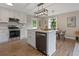 A modern kitchen featuring an island, stainless steel appliances, and wood floors at 306 Birch St, Canton, GA 30114