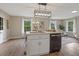 Bright, open kitchen with modern island, lighting, stainless dishwasher, and hardwood flooring at 306 Birch St, Canton, GA 30114