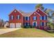 Traditional two-story brick home with a two-car garage and well-maintained lawn on a sunny day at 3071 Springfair Trott, Lithonia, GA 30038