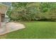 Expansive backyard with lush green grass, mature trees, and a patio area at 3918 Oberlin Ct, Tucker, GA 30084