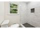 Bathroom featuring marble tiled shower, hexagon floor tiles, and toilet near a window at 3918 Oberlin Ct, Tucker, GA 30084