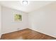 This bedroom has wood floors, white walls, a window, and overhead lighting at 3918 Oberlin Ct, Tucker, GA 30084