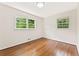 This is a bedroom with wood floors and two windows that let in lots of light at 3918 Oberlin Ct, Tucker, GA 30084