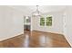 Dining room featuring hardwood floors and modern light fixture next to a kitchen with gray cabinets at 3918 Oberlin Ct, Tucker, GA 30084