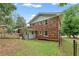Exterior view of brick home showcasing fenced yard and mature trees at 3918 Oberlin Ct, Tucker, GA 30084