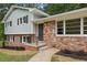 Close up of a brick home with light gray siding, black shutters, and professionally landscaped beds at 3918 Oberlin Ct, Tucker, GA 30084