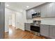 Contemporary kitchen featuring gray cabinets, stainless steel appliances, and hardwood floors at 3918 Oberlin Ct, Tucker, GA 30084