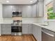 Modern kitchen with gray cabinets, stainless steel appliances, quartz countertop, and subway tile backsplash at 3918 Oberlin Ct, Tucker, GA 30084