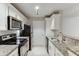 Well-lit kitchen with stainless steel appliances, white cabinets, and granite countertops at 4106 Santa Fe Pkwy, Atlanta, GA 30350