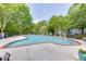 Community pool featuring lounge chairs, shade umbrellas, and mature landscaping at 4106 Santa Fe Pkwy, Atlanta, GA 30350