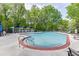 Community pool featuring lounge chairs, shade umbrellas, and mature landscaping at 4106 Santa Fe Pkwy, Atlanta, GA 30350