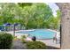 Community pool featuring lounge chairs, shade umbrellas, and mature landscaping at 4106 Santa Fe Pkwy, Atlanta, GA 30350