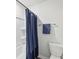 Clean bathroom featuring a white tub/shower and a toilet, accented with a blue shower curtain at 1451 Stephens View Dr, Loganville, GA 30052