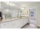 Bathroom boasts dual vanities, granite countertops, wood-look floors, and a large framed mirror at 1451 Stephens View Dr, Loganville, GA 30052