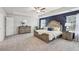 Spacious main bedroom with a tray ceiling features a dark accent wall and neutral carpet at 1451 Stephens View Dr, Loganville, GA 30052