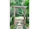 Stone path and landscaped backyard with a wooden archway framing the verdant green lawn at 2639 Acorn Ne Ave, Atlanta, GA 30305