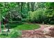 Lush backyard featuring a circular lawn, stone pathway, mulch, and mature landscaping, offering a serene outdoor space at 2639 Acorn Ne Ave, Atlanta, GA 30305
